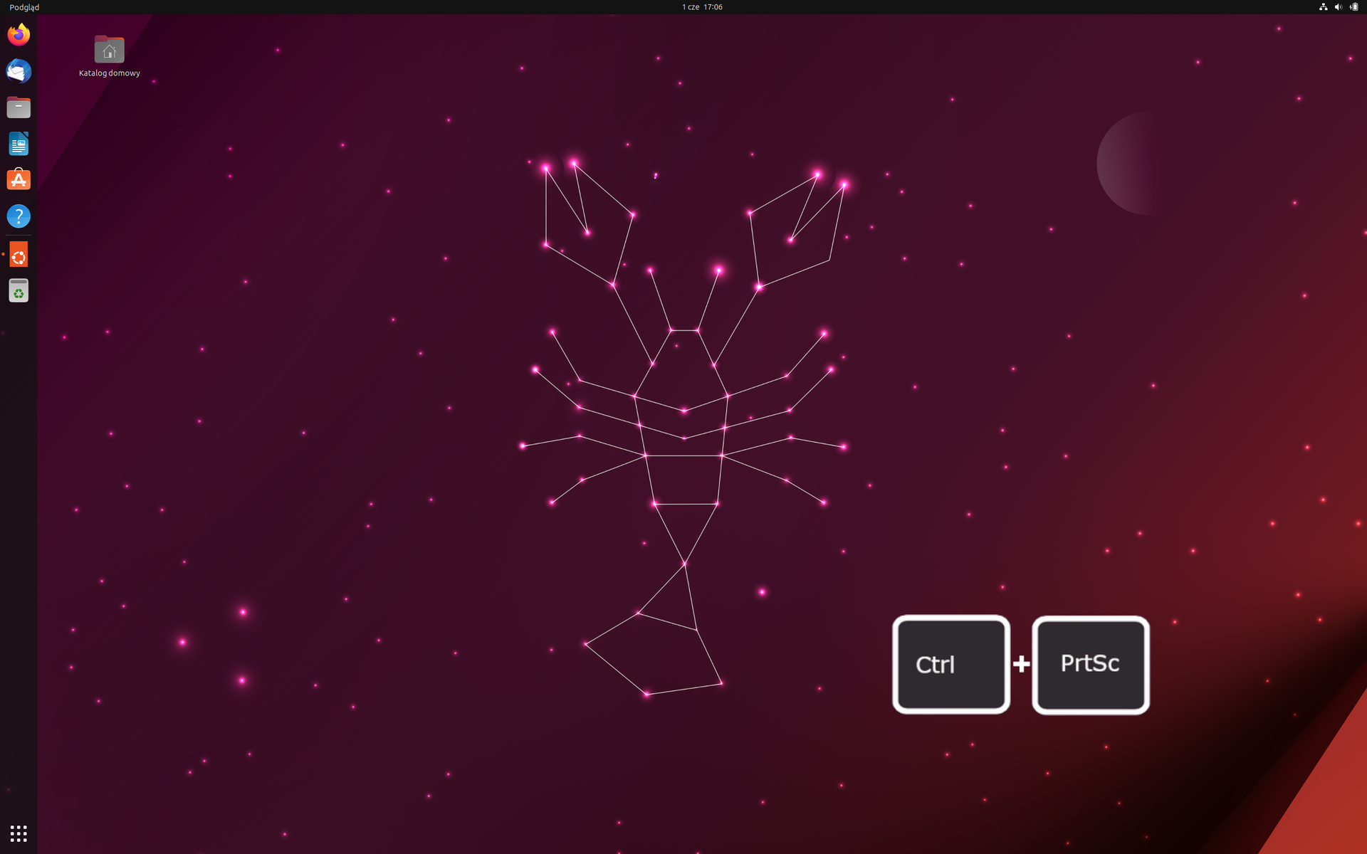 Ilustracja przedstawia pulpit Ubuntu w wersji 23.04. Na tapecie znajduje się homar złożony z figur geometrycznych. W lewym górnym rogu znajduje się ikona kosza. Na pulpicie umieszczono grafikę przedstawiającą kombinację klawiszy Ctrl oraz PrtSc.