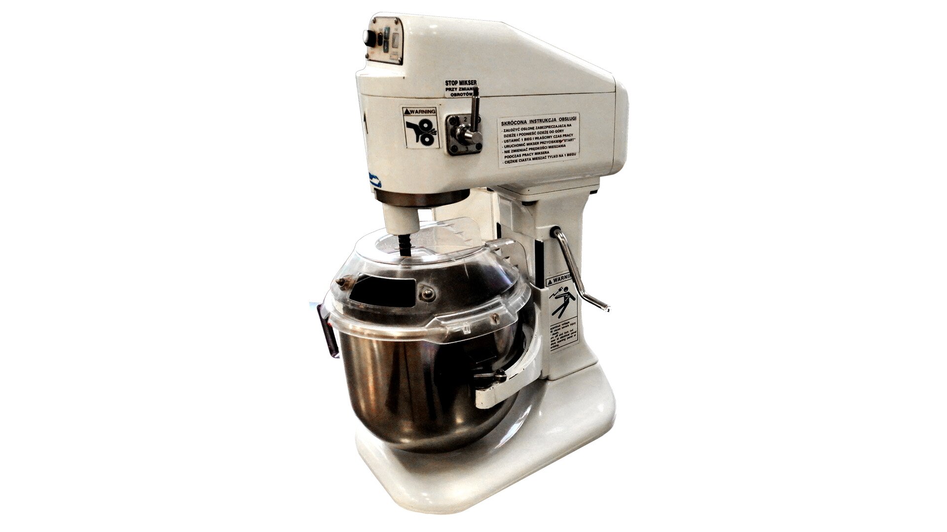 Zdjęcie przedstawia miesiarkę spiralną, w ujęciu trzy czwarte. Widać korpus miesiarki z pokrywą górną, w kolorze białym oraz dzieżę miesiarki, czyli misę, wykonaną ze stali nierdzewnej. Górna część dzieży przykryta jest przeźroczystą osłoną, z niewielkim otworem, w którym znajduje się narzędzie do mieszania. W górnej części białego korpusu widoczne jest pokrętło włączania i wyłączania wykonane ze stali nierdzewnej. Poniżej na korpusie znajduje się dźwignia zmiany prędkości, wykonana ze stali nierdzewnej.