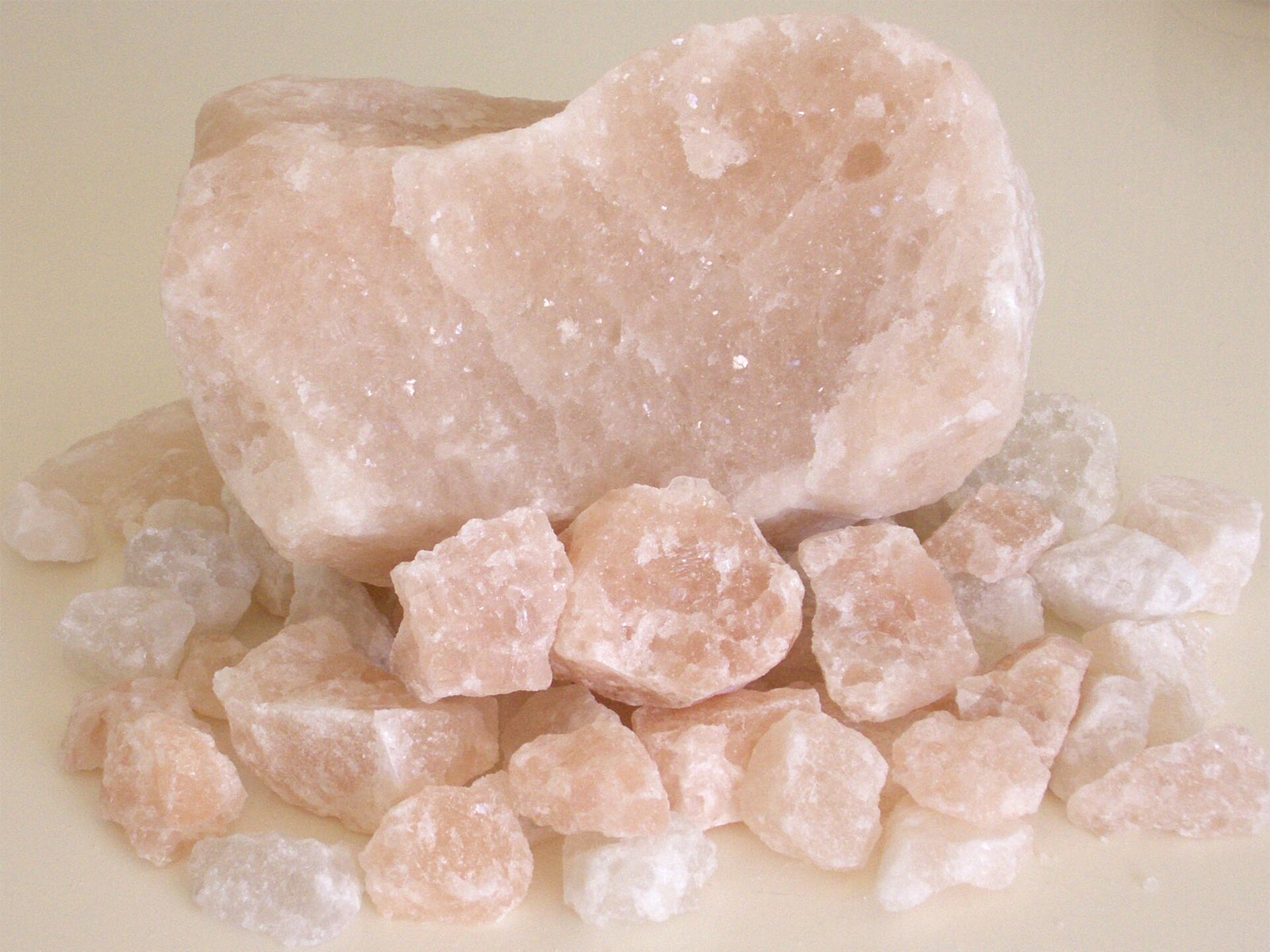 Na zdjęciu przedstawiona jest sól kamienna – kilka bryłek w postaci nieregularnych wieloboków. Jedna duża, wielkości pięści i kilkanaście małych, wielkości kostki do gry. Barwa różowa, szklista.