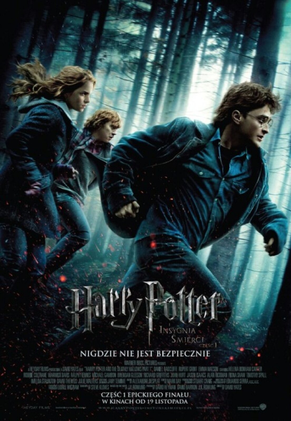 Ilustracja przedstawia plakat do filmu „ Harry Potter  – INSYGNIA ŚMIERCI”. W centrum zdjęcia, na tle mrocznego lasu ukazane zostały biegnące postacie dwóch chłopców i dziewczyny ubranych w kurtki i jeansy. Całość kompozycji utrzymana jest w chłodnej, niebiesko‑czarnej tonacji. Na dole znajduje się duży napis „ Harry Potter ” natomiast pod nim mniejszą czcionką „INSYGNIA ŚMIERCI”. Poniżej umieszczony został blok tekstowy z informacjami na temat filmu.