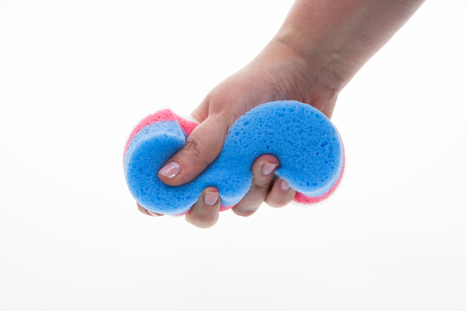 Na fotografii zaprezentowano zbliżenie ręki człowieka ściskającej gąbkę kąpielową. Gąbka pod naciskiem palców zmienia swój kształt i jest przykładem substancji sprężystej.