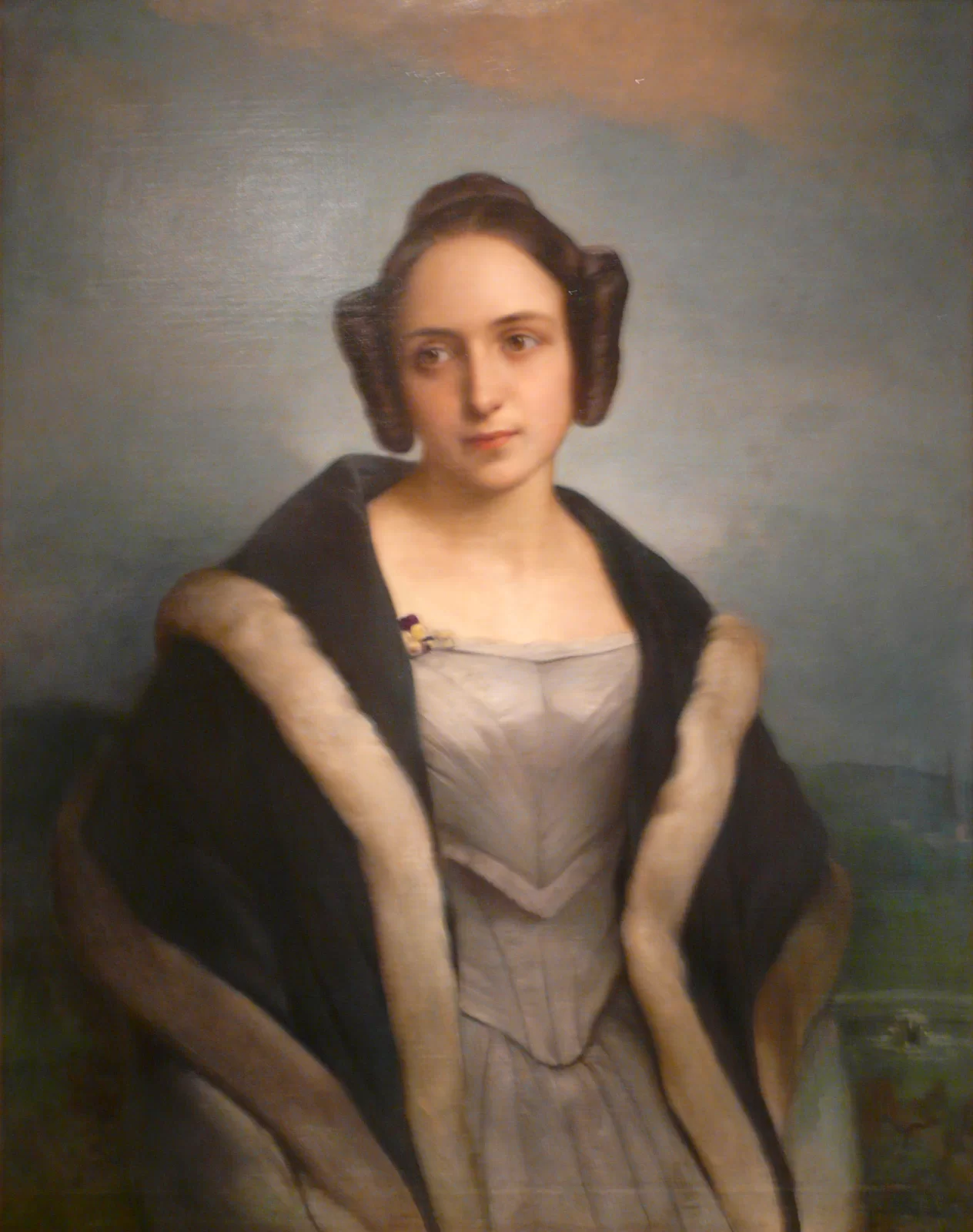 Portret Anny z Sapiehów Czartoryskiej. Na ilustracji kobieta wpatrzona wzrokiem w jakiś punkt. Ubrana w długą suknię. Na plecach ma zarzucony długi szal, obszyty futerkiem.