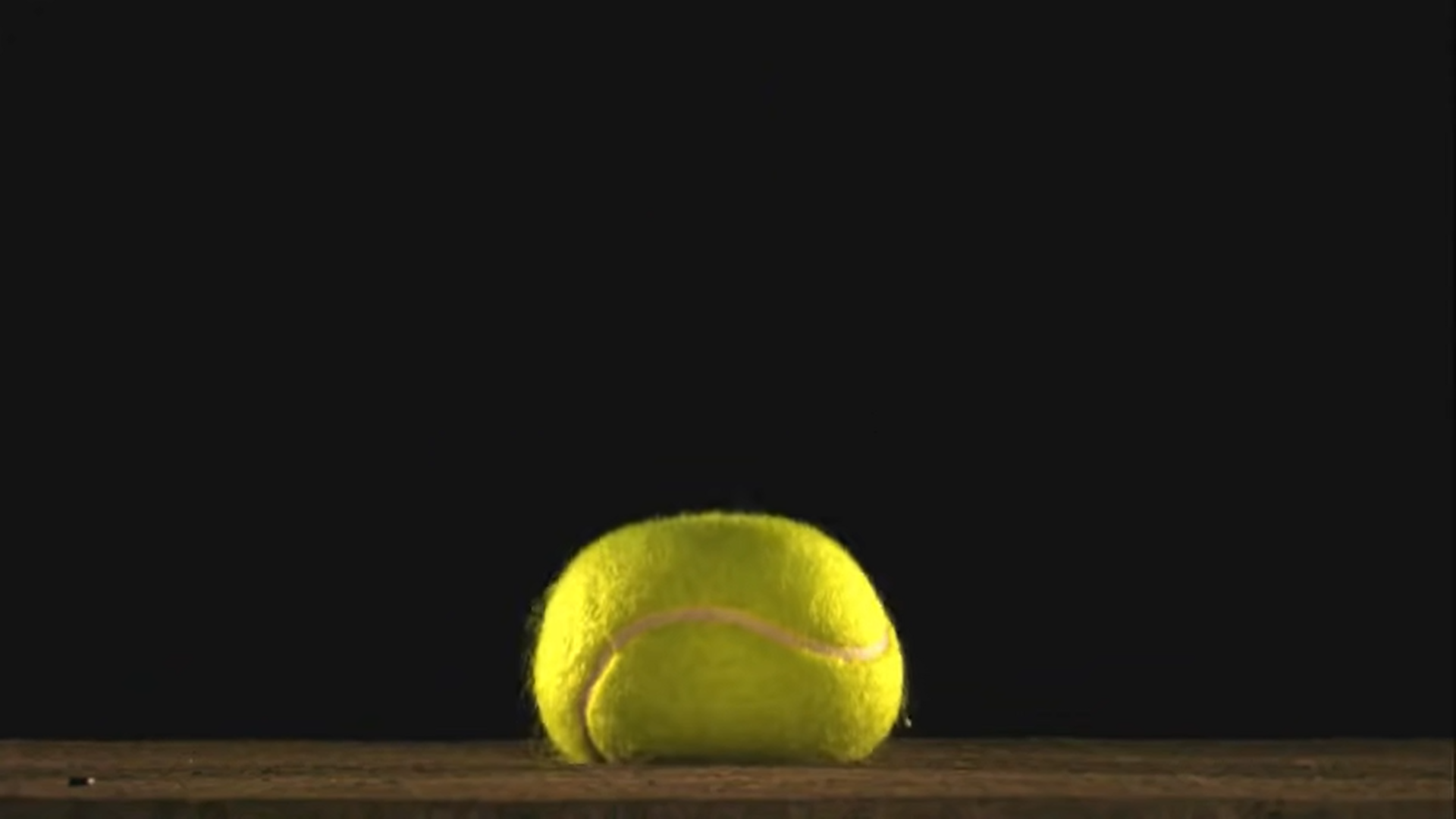 Rys. 4. Zdjęcie przedstawia odkształconą piłkę tenisową "przyklejoną" do podłogi. Piłka zderzając się z podłogą podczas odbijania spłaszcza się (odkształca się) chwilowo.