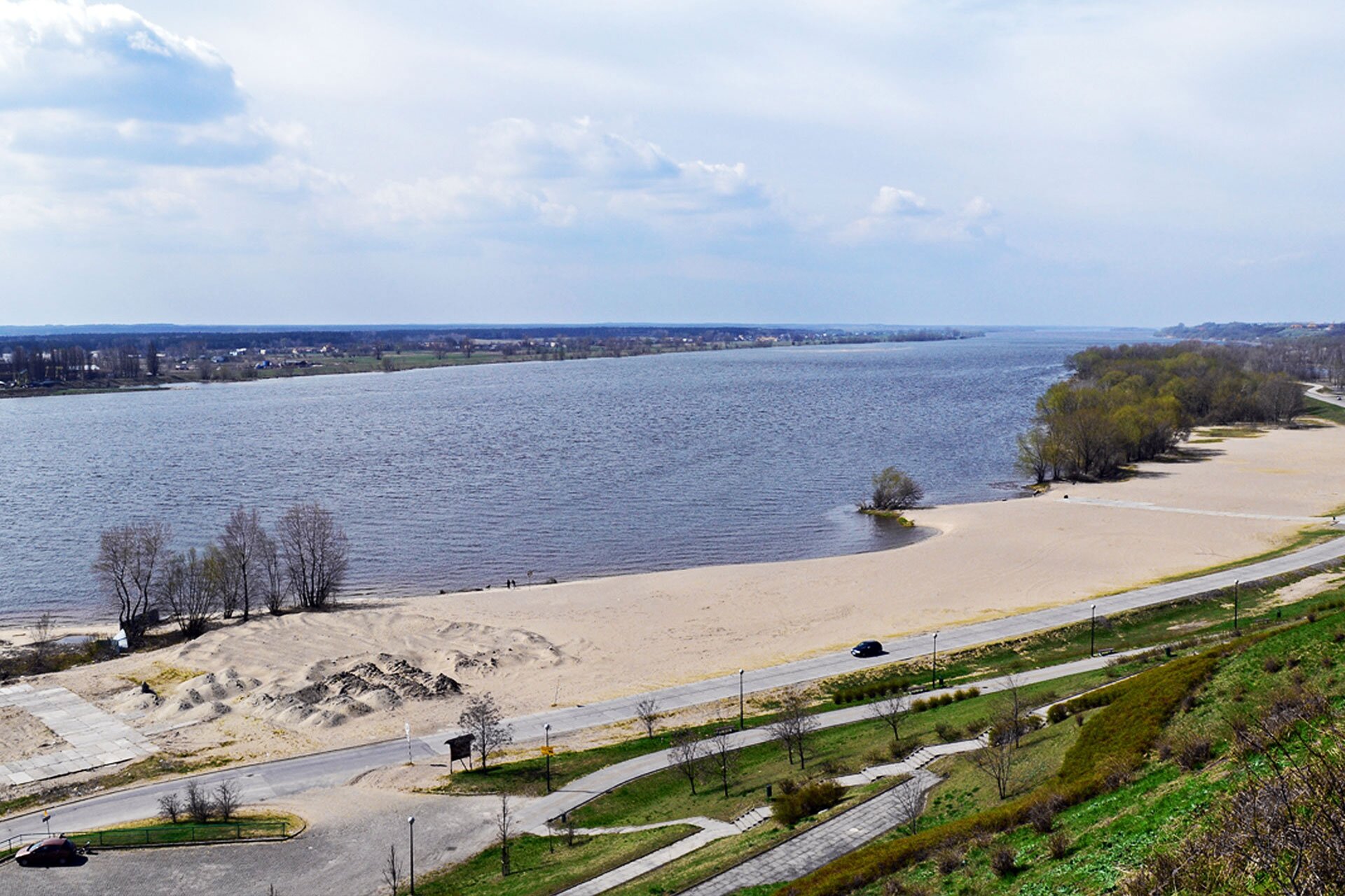 Zdjęcie przedstawia dolny bieg rzeki. Koryto rzeki jest bardzo szerokie. Widoczne są piaszczyste plaże na bliższym brzegu.