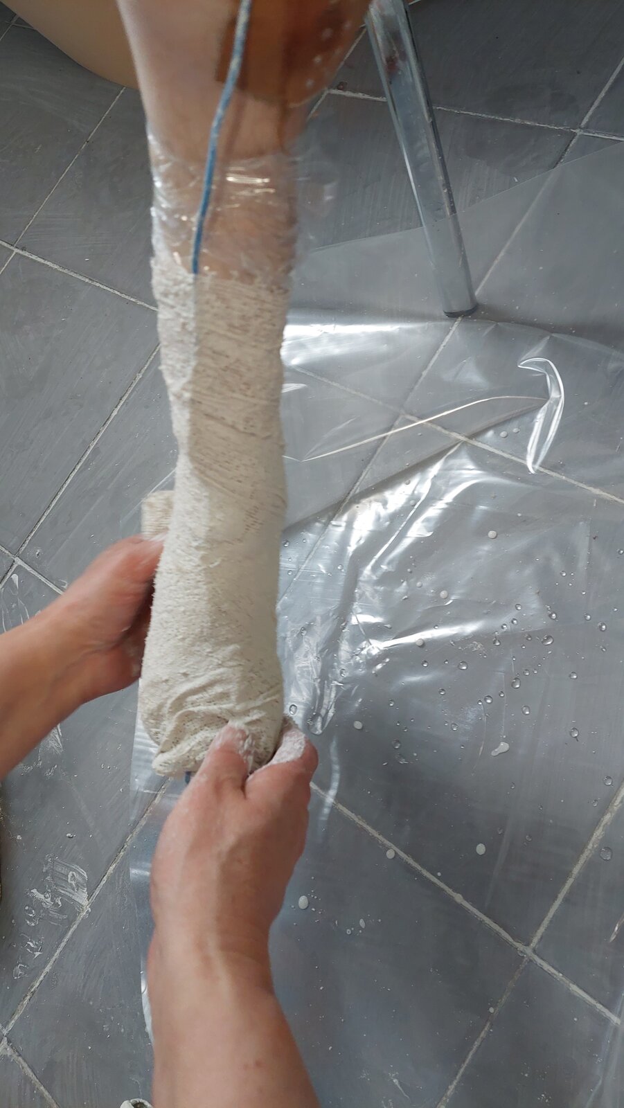 Zdjęcie przedstawia stopę z nałożonymi opaskami gipsowymi, w celu wykonania formy do odlewu.