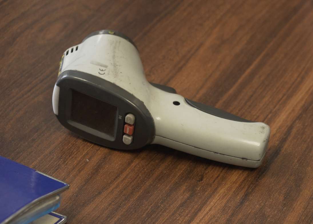 Zdjęcie przedstawia pirometr  Urządzenie znajduje się na blacie. Urządzenie wyposażone jest w uchwyt pistoletowy. Na nim osadzona jest nieduża prostopadłościenna część odpowiadająca za pomiar. Po jednej stronie znajduje się prostokątny wyświetlacz. Poniżej ekranu wbudowane są trzy przyciski. Pirometr leży na biurku.