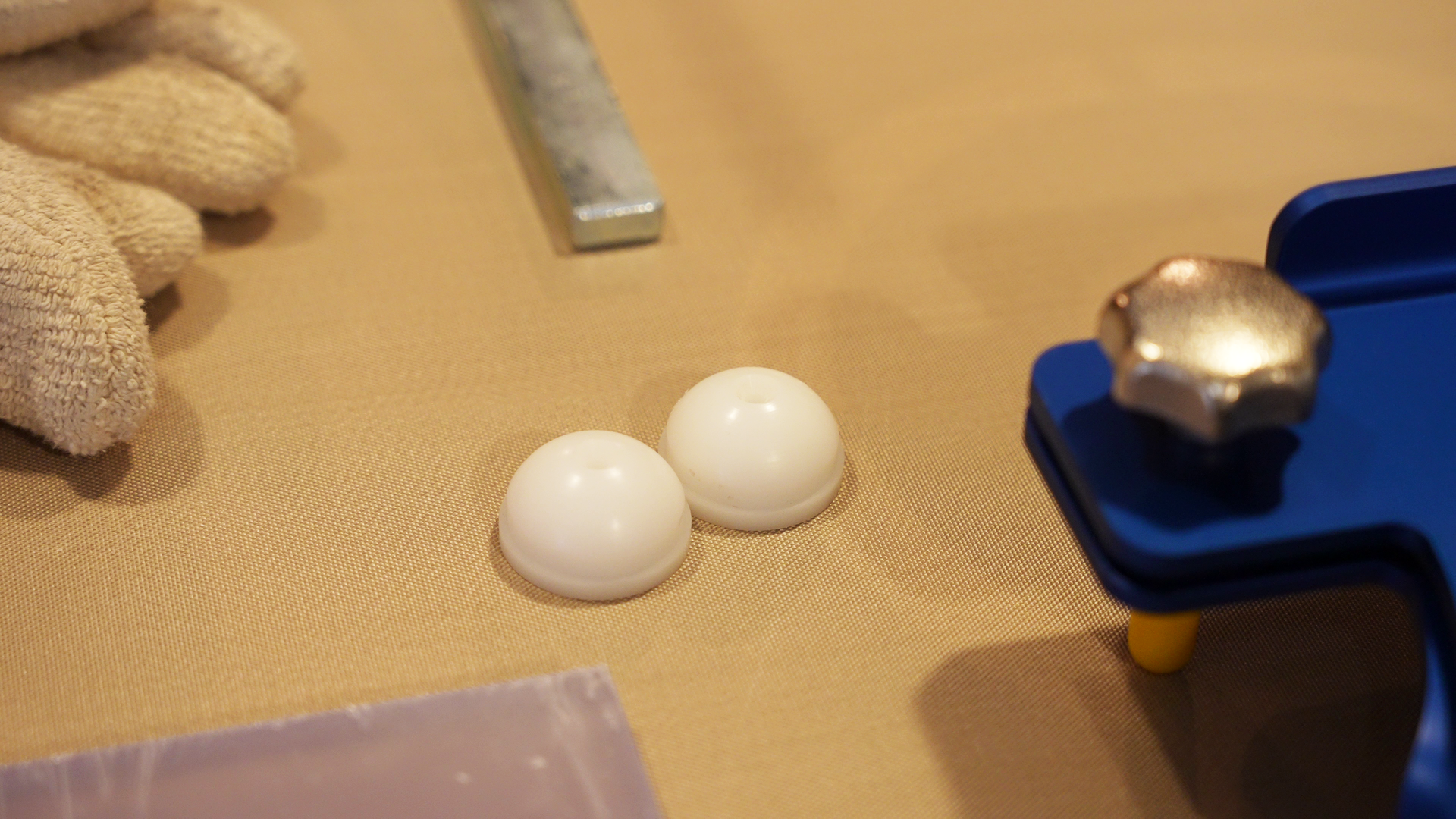 Zdjęcie przedstawia dwie kształtki. Są to elementy zastępcze docelowej części wytwarzanego przedmiotu wykorzystywane na różnych etapach pracy. Kształtki znajdują się na blacie. Mają kształt półkul i są koloru białego.