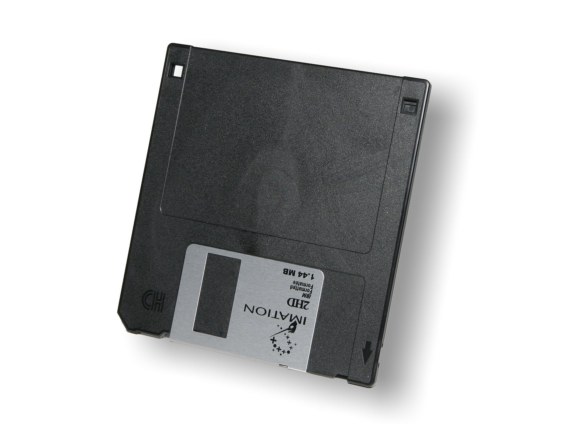 Na fotografii znajduje się czarna dyskietka komputerowa z metalową częścią, na której są odwrócone napisy: Imation, 2HD, 1.44MB. Tło jest białe.