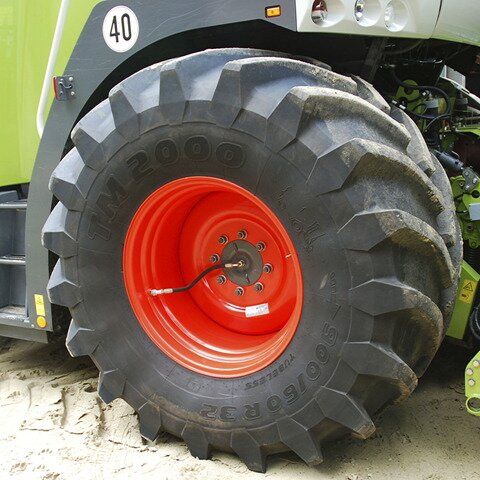 Ilustracja przedstawia koło samochodu terenowego lub ciężarówki. Ma wydatny bieżnik opon. 