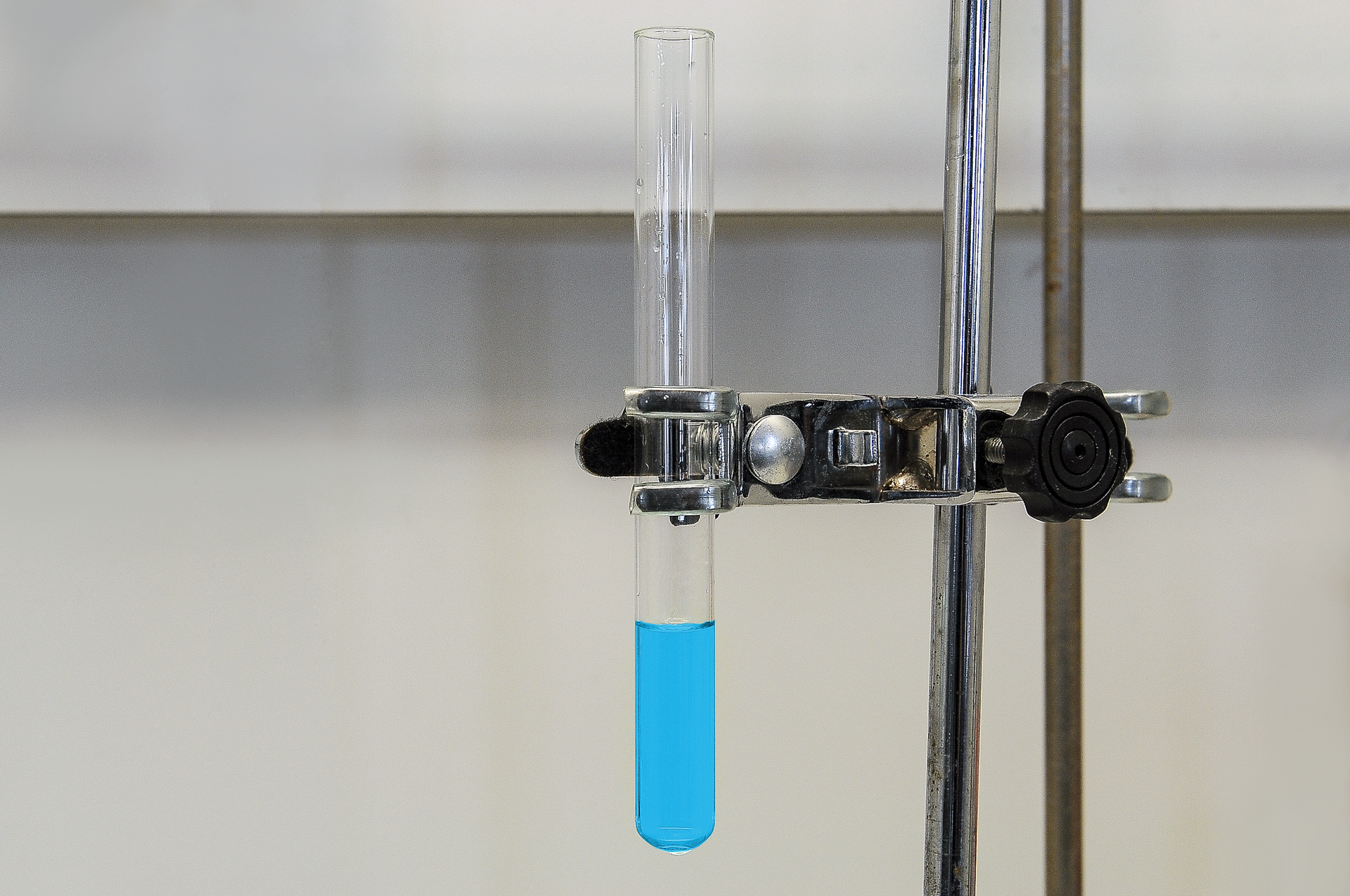 Ilustracja przedstawia probówkę z jasnoniebieską substancją. Efekt połączenia tlenku miedzi dwa z kwasem octowym.