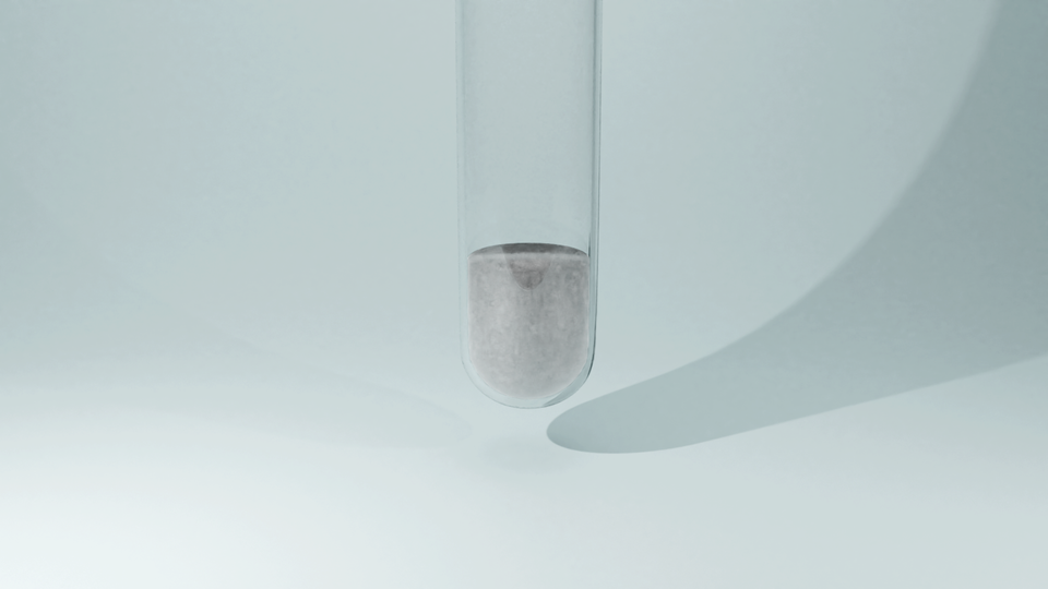 Zdjęcie przedstawiające szklaną probówkę, w której znajduje się biały kłaczkowaty osad chlorku srebra(jeden), który fioletowieje na powietrzu.