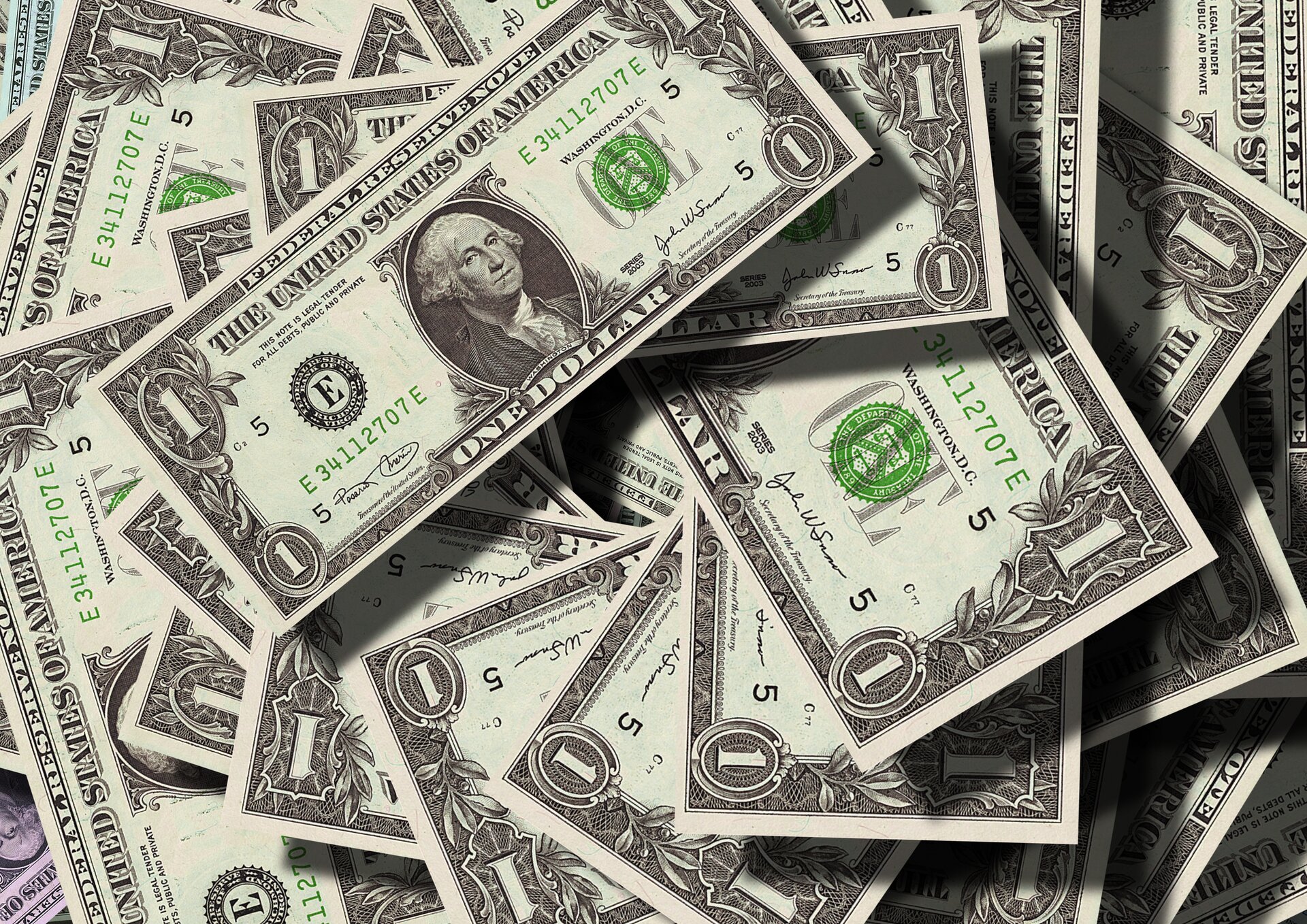 Na zdjęciu znajdują się dolary amerykańskie - banknoty o nominale jednego dolara rozsypane spontanicznie. Jeden z banknotów 1‑dolarowych z podobizną George'a Washingtona jest widoczny w całości.