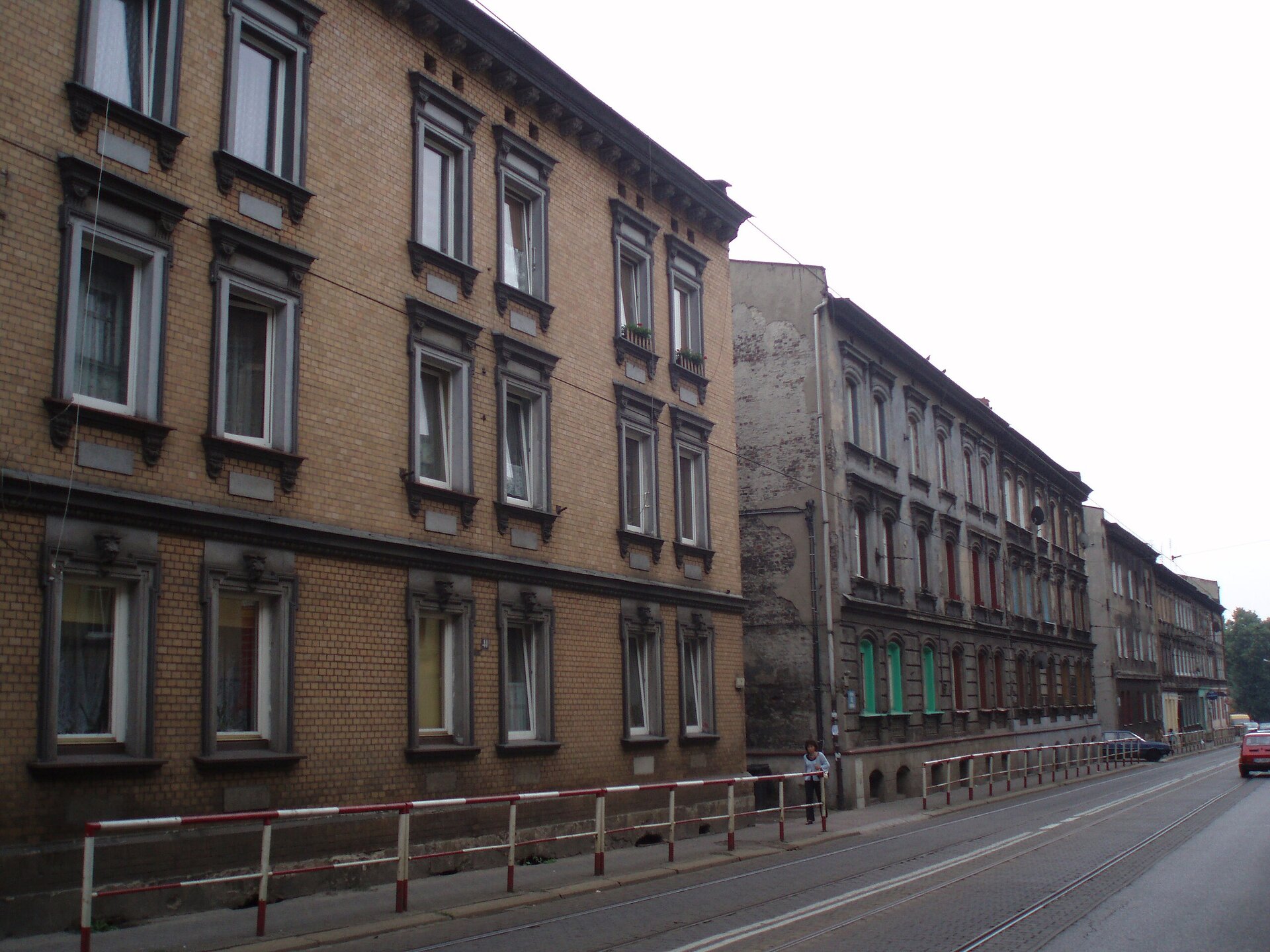 Kliknij, aby powiększyć Zdjęcie przedstawia ciąg trzykondygnacyjnych budynków, które zlokalizowane są przy wytyczonej po 1880 roku na Klimzowcu w Chorzowie ulicy. Domy są wykonane z cegły i nieotynkowane. Kondygnacje przedzielone są ryzalitami, a okna obramowane z płaskimi frontonami. Pod dachem budowli biegnie dekoracyjny gzyms.