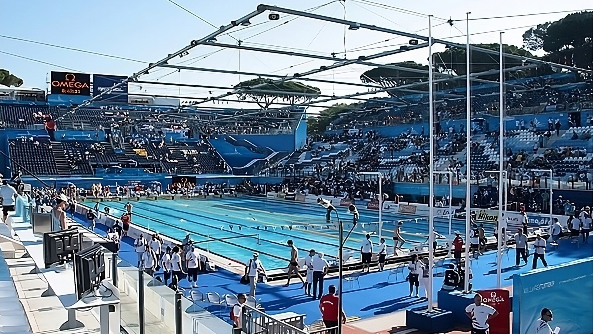 Zdjęcie przedstawia odkryty basen pływacki. Na basenie znajdują się ludzie.