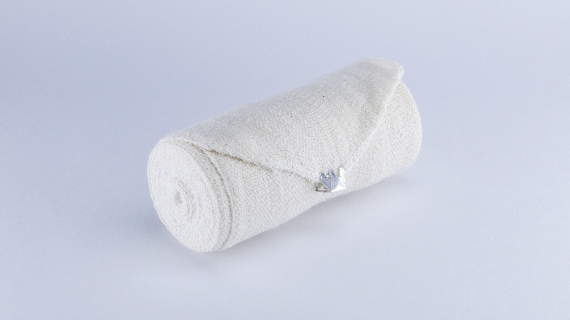 Zdjęcie przedstawia rolkę bandażu elastycznego.