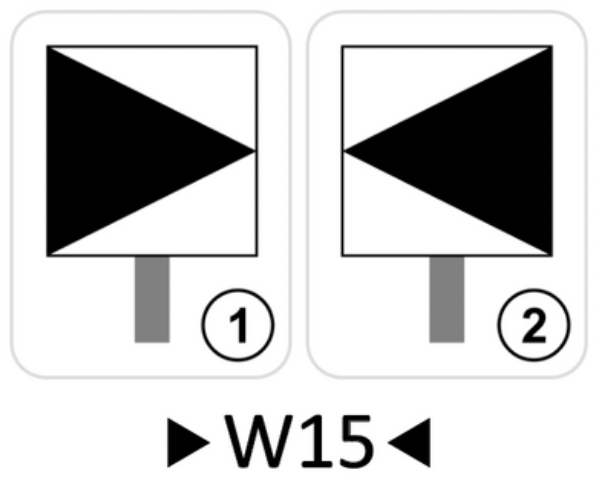 Wskaźnik wu piętnaście. Przedstawiono tu dwa znaki. Oba mają kształt białej kwadratowej tablicy z czarnym trójkątem zwróconym wierzchołkiem w kierunku sygnalizatora. Trójkąt jest równoramienny, a jedna z jego podstaw pokrywa się z bokiem znaku. Na pierwszym znaku, podstawa trójkąta pokrywa się z lewym pionowym bokiem, a wierzchołek styka się z prawym pionowym bokiem. Drugi znak jest odbiciem lustrzanym pierwszego.