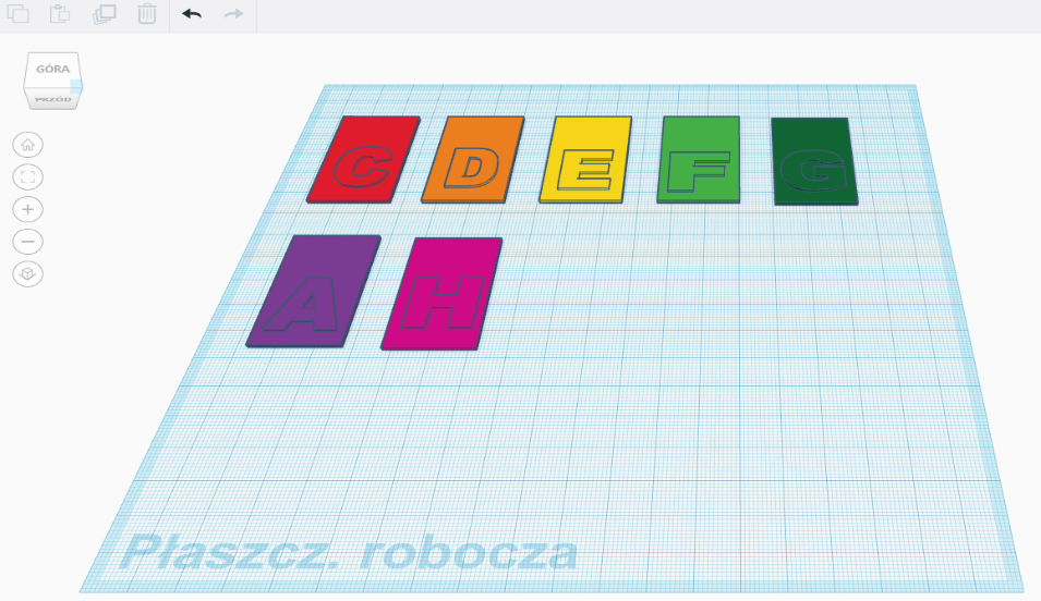 Zrzut ekranu z aplikacji Tinkercad. Widok z góry na niebieską planszę pokrytą cienką kratką. Na planszy, przy górnej krawędzi, ułożone w dwóch rzędach schematycznie zaprojektowane prostokątne, kolorowe klawisze. Na każdym klawiszu widać uwypukloną literę alfabetu. Klawisze ustawione są w kolejności, w pierwszym rzędzie: czerwony klawisz z literą C, pomarańczowy klawisz z literą D, żółty klawisz z literą E, jasnozielony klawisz z literą F, ciemnozielony klawisz z literą G. W drugim rzędzie: fioletowy klawisz z literą A, różowy klawisz z literą H. W lewym górnym rogu zrzutu na górze widać belkę zawierającą ikony kopiowania, powielania, zapisywania. usuwania i cofania czynności. Po lewej widać elementy interfejsu programu służące obracaniu projektów 3D, powiększeniu i zmniejszaniu.