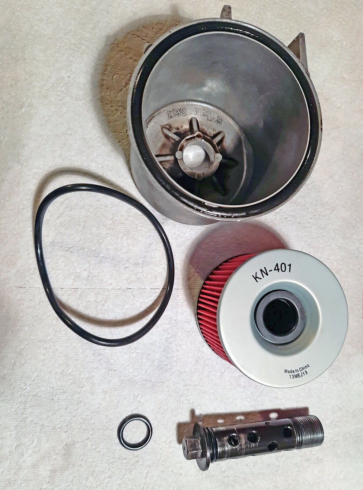 Na ekranie przedstawione obudowa i wkład filtra oleju dokładnego oczyszczania - filtr w obudowie obcej. Widoczna oś filtra i uszczelki o‑ringowe.