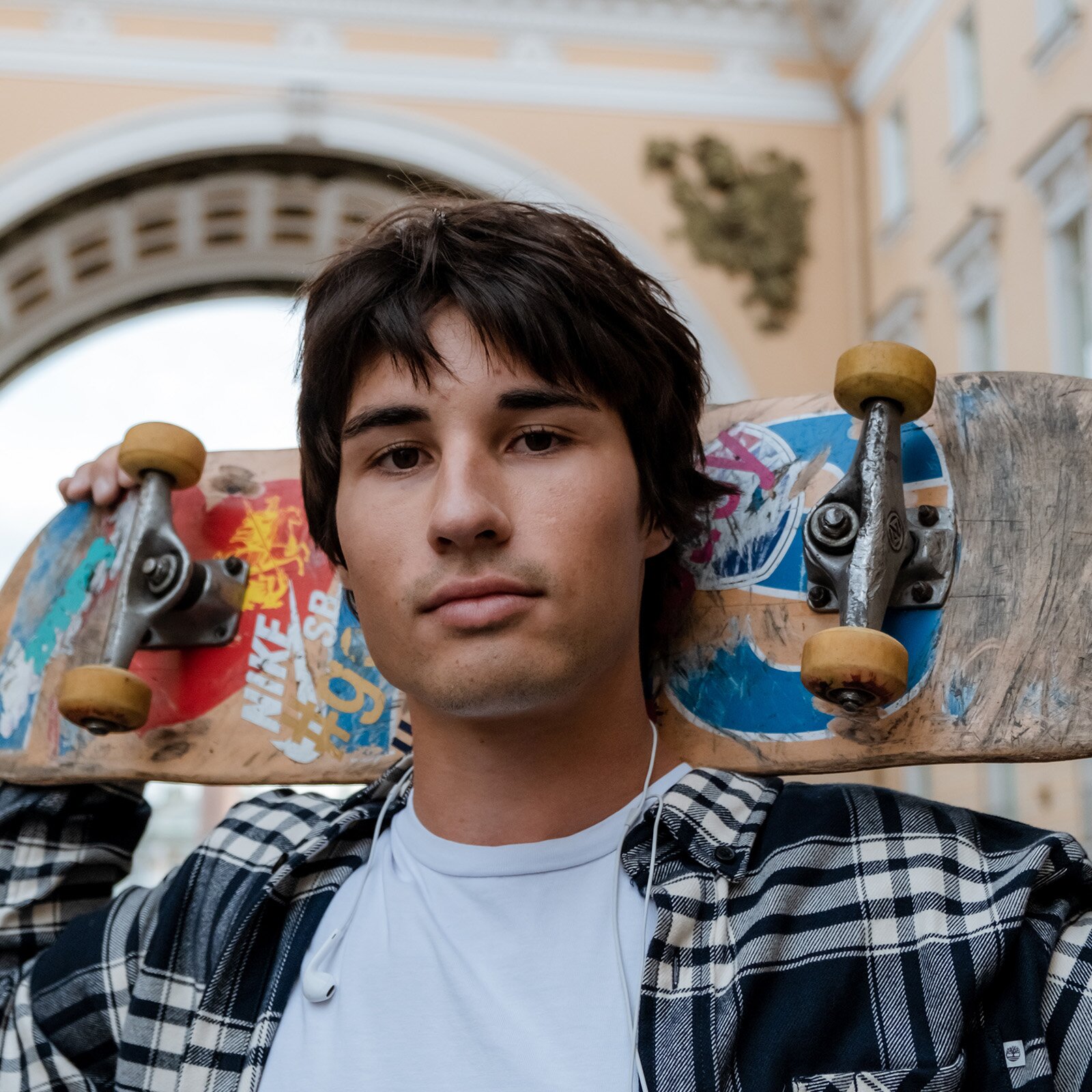 Zdjęcie przedstawia ciemnowłosego nastolatka. Jego oczy są ciemne i oprawa oczu również ciemna. Ma lekko opaloną skórę. 