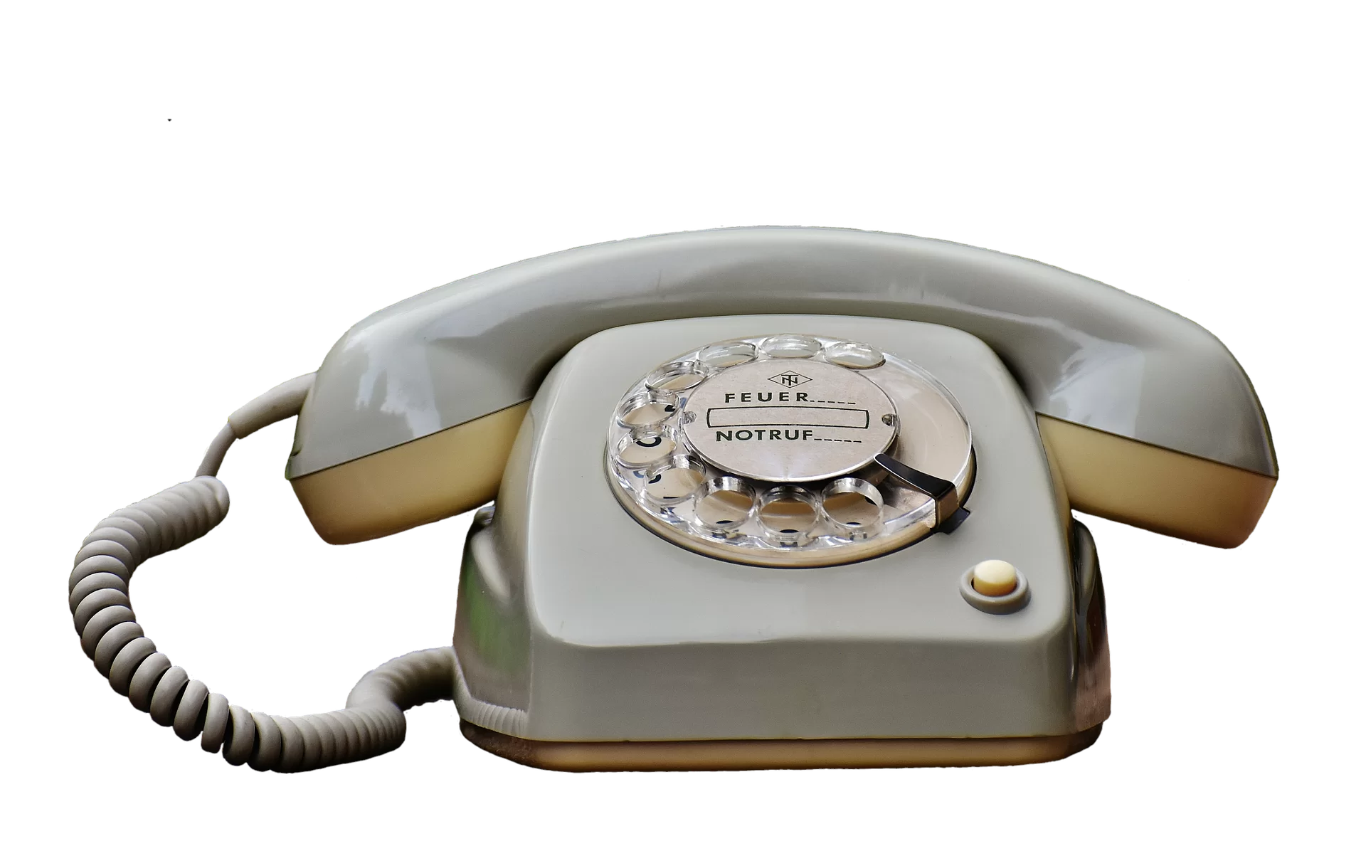 Kliknij, aby powiększyć Na zdjęciu przedstawiony jest telefon z okrągłą tarczą z numerami od 0 do 9. Wybierało się numer wkładając palec w otwór umieszczony przy cyfrze i kręciło się pełny obrót, zgodnie z kierunkiem zegara. Do podstawy kablem połączona jest słuchawka.
