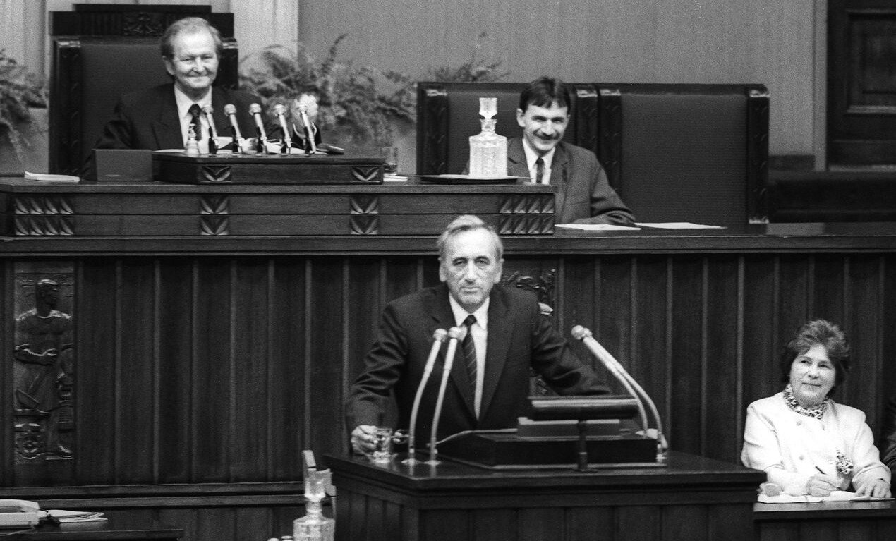 Fotografia czarno-biała przedstawiająca Premiera Tadeusza Mazowieckiego wygłaszającego Exposé z mównicy sejmowej.