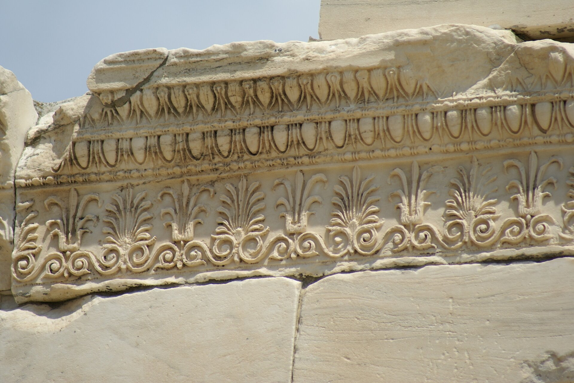 Wykonane zdjęcie przedstawia fragment ściany w beżowym odcieniu. Jest on bogato zdobiony motywami roślinnymi.