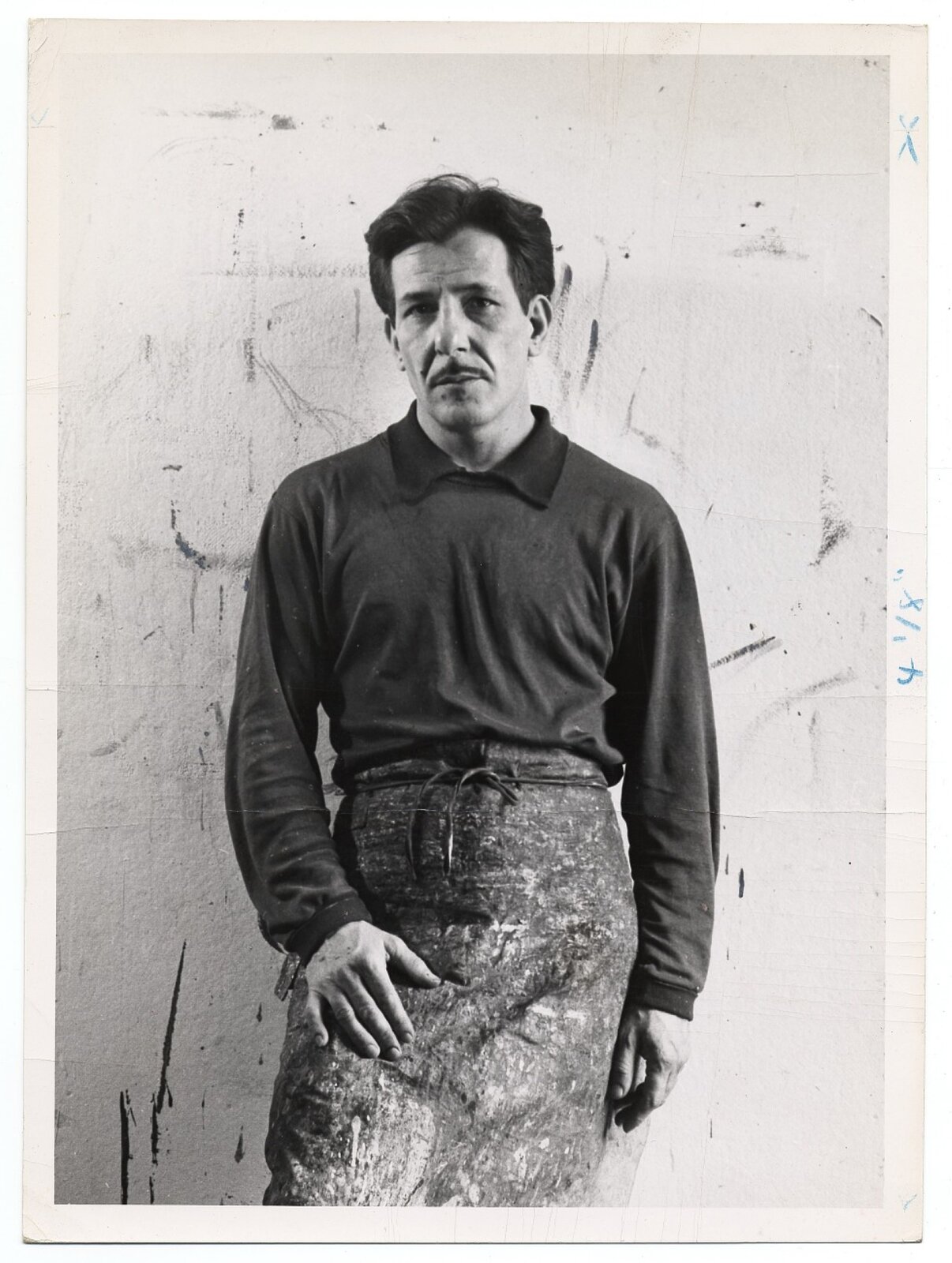 Fotografia przedstawia Franza Kline [czytaj: franca kline], który został sportretowany na tle białej ściany. Kline to mężczyzna w średnim wieku, o średniej długości włosach zaczesanych na lewo i małym wąsie, ubrany jest w spodnie robocze, poszarpaną koszulkę. Kline ma neutralny wyraz twarzy i ze spokojem spogląda w obiektyw aparatu.