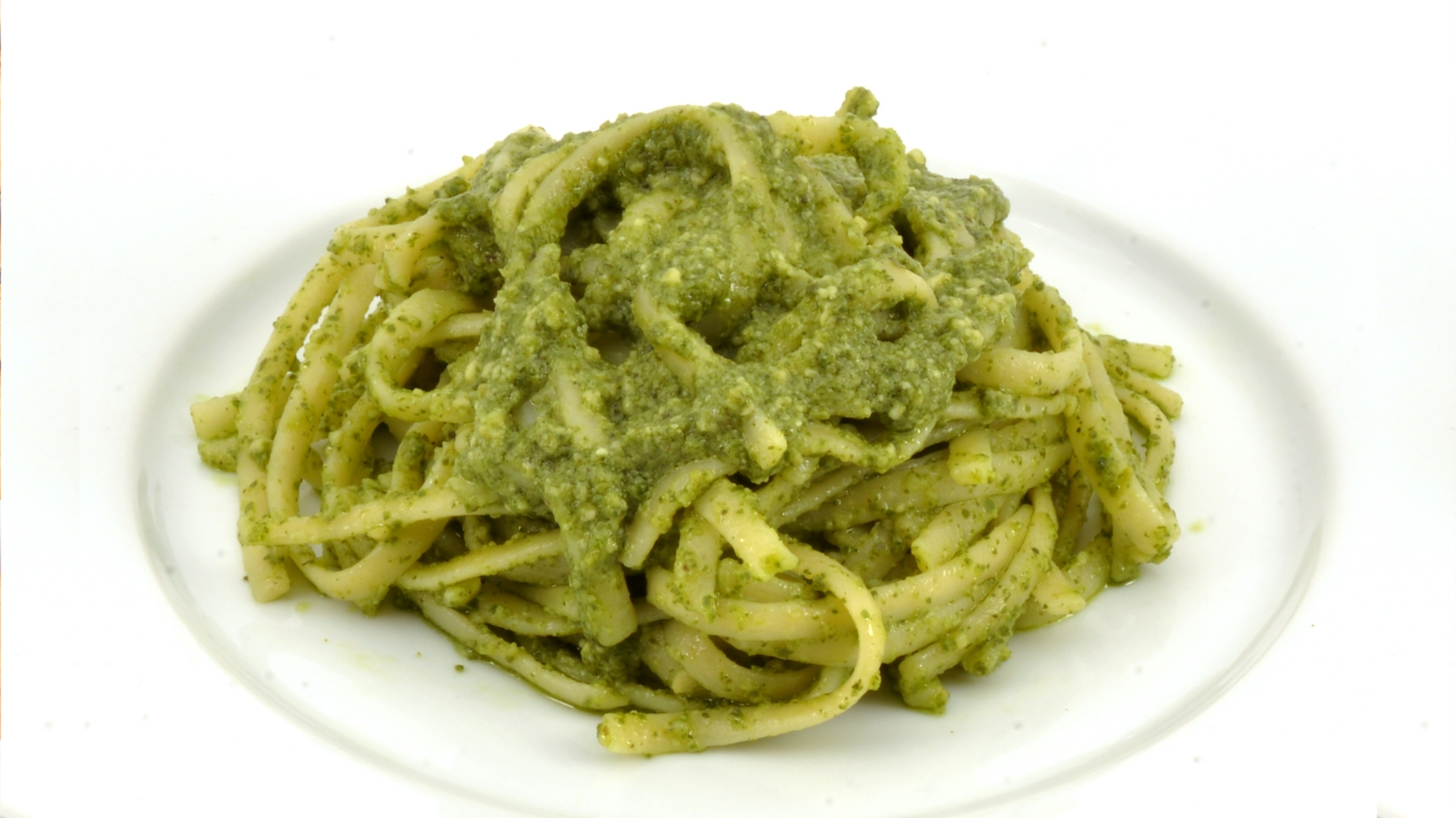 Zdjęcie przedstawia makaron z pesto na talerzu.