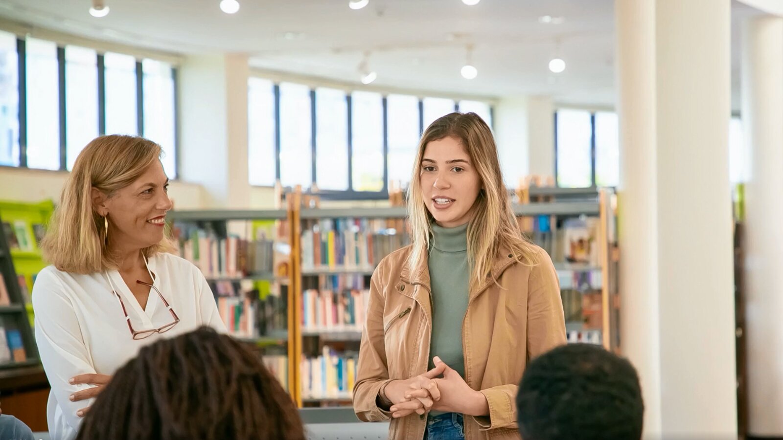   Um eine Sprache zu beherrschen, musst du sie möglichst oft nutzen. Es ist klar, dass man dabei viele Fehler begeht. Wichtig ist aber, aus diesen Fehlern zu lernen und das nächste Mal zu versuchen, sie (also die Fehler) zu reduzieren. Hab keine Angst vorm Schreiben oder Sprechen in der Fremdsprache – nur auf diese Art und Weise kannst du sie schließlich erlernen.
Jeder Fehler, den du machst, bringt dich deinem Ziel näher.
11. Keine Angst haben, Fehler zu mache
Um eine Sprache zu beherrschen, musst du sie möglichst oft nutzen. Es ist klar, dass man dabei viele Fehler begeht. Wichtig ist aber, aus diesen Fehlern zu lernen und das nächste Mal zu versuchen, sie (also die Fehler) zu reduzieren. Hab keine Angst vorm Schreiben oder Sprechen in der Fremdsprache – nur auf diese Art und Weise kannst du sie schließlich erlernen.
Ilustracja przedstawia wnętrze biblioteki. Młoda dziewczyna stoi przed słuchaczami obok niej starsza kobieta obserwuje ją z uśmiechem.

