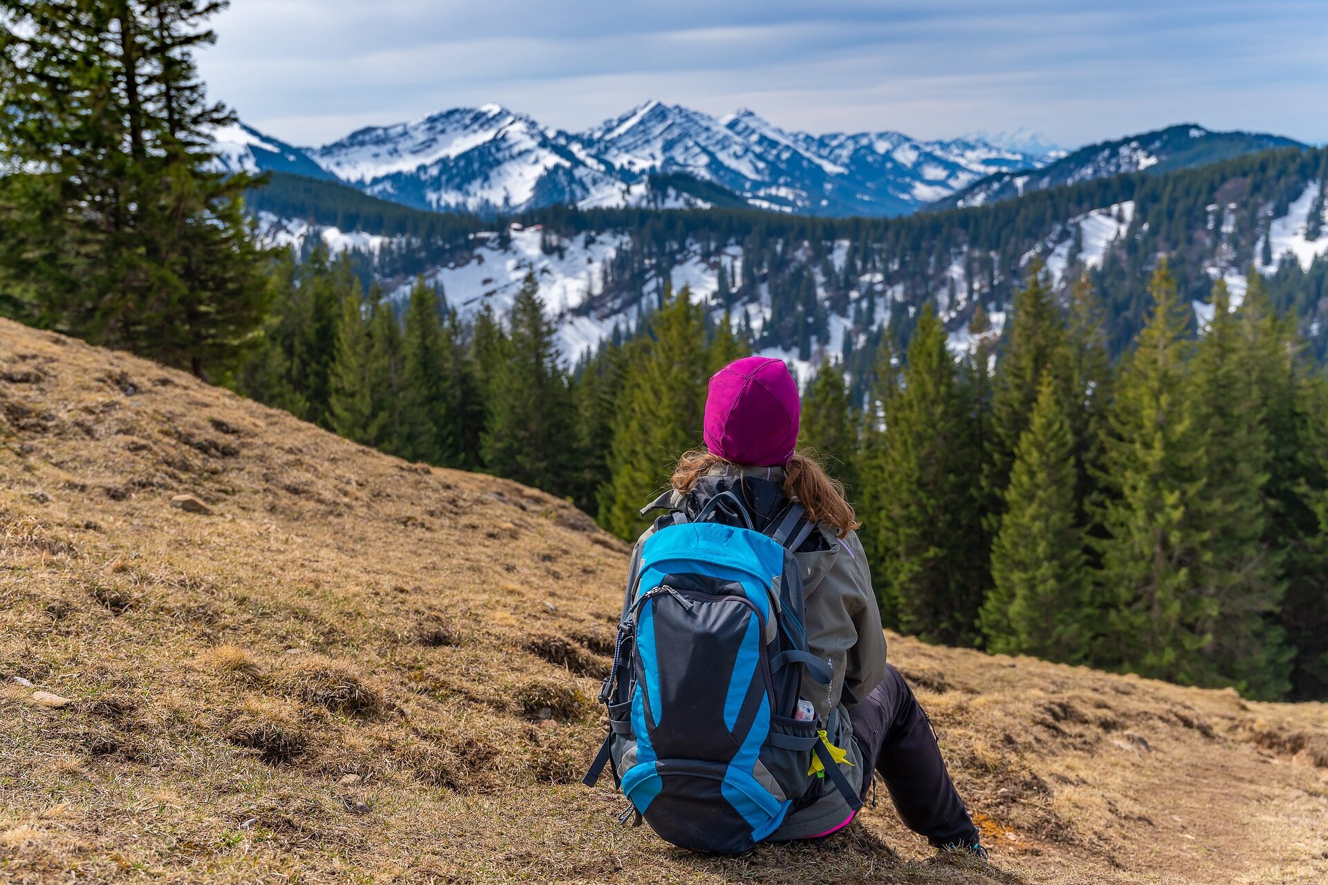 Ilustracja przedstawia turystkę odpoczywającą po górskiej wspinaczce.