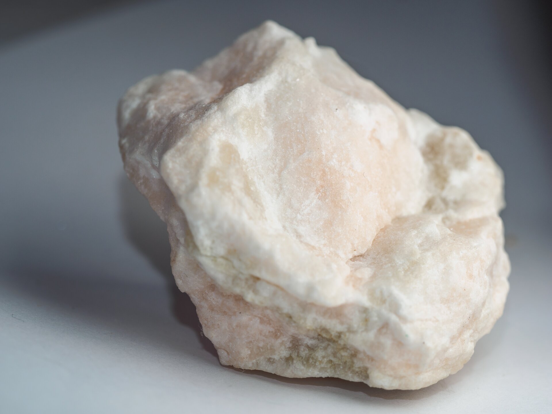 Zdjęcie przedstawia gips. Jest to minerał o delikatnych nierównościach. Ma białą barwę.