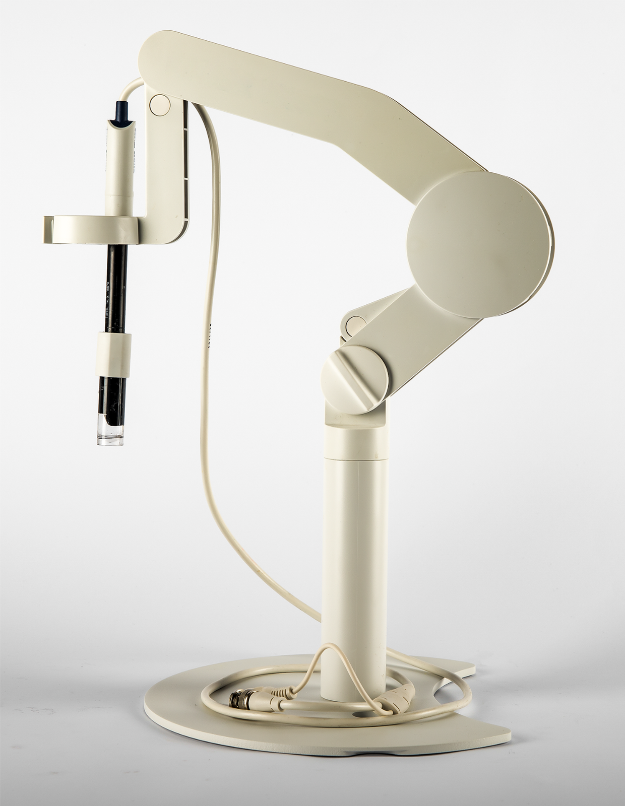 Zdjęcie przedstawia pehametr, urządzenie do mierzenia stężenia jonów wodorowych w roztworze badanym (pH). Widoczna jest szklana elektroda umieszczona w statywie. 