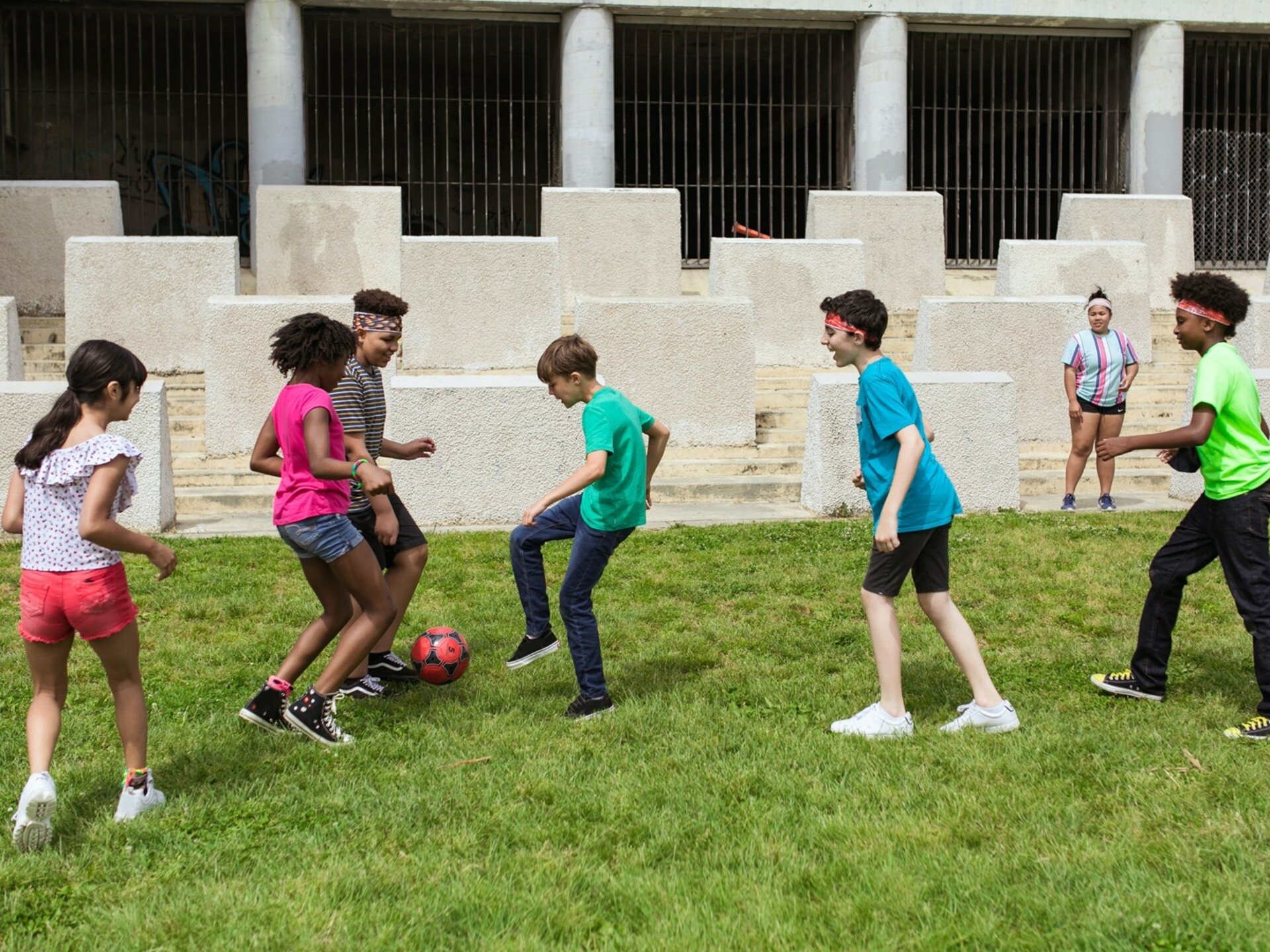 Zdjęcie przedstawiające grupkę dzieci grających w piłkę nożną.