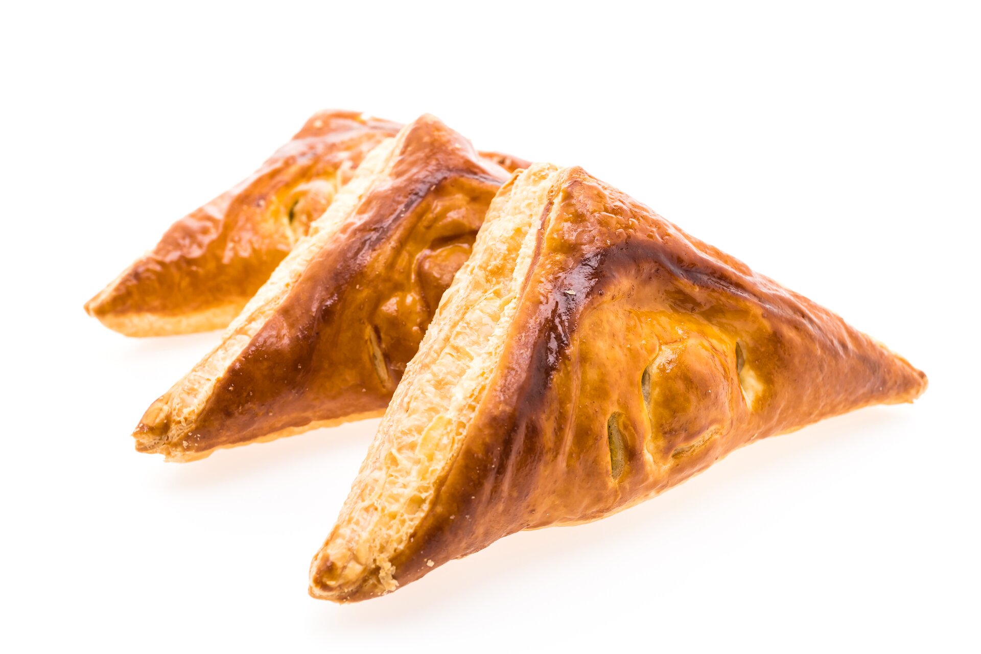 Ciastka koloru złocistego, z nadzieniem, złożone tak, jak składa się serwetki (w kształt trójkąta).