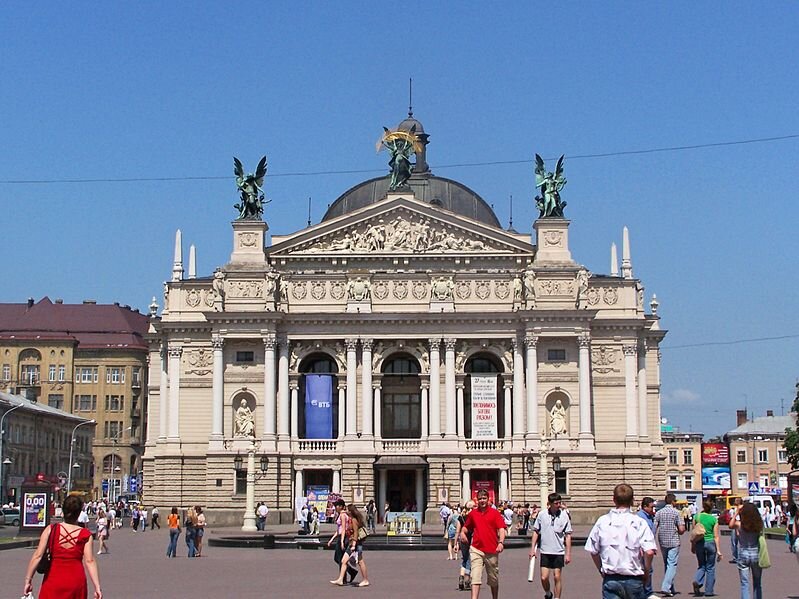 Na ilustracji znajduje się budynek, który ma kształt prostokąta. W pierwszej kondygnacji jest usytuowana trójłukowe arkada. Znajdują się też podwójne kolumny korynckie. Budowla jest zwieńczona kopułą. Attykę zdobią figury Muz. Przestrzeń między oknami wypełniają kolumny jońskie. W niszach po obu stronach głównego wejścia stoją alegoryczne postacie Komedii i Tragedii. Drzwi wejściowe zdobią kolumny doryckie. Przed budynkiem spacerują ludzie.