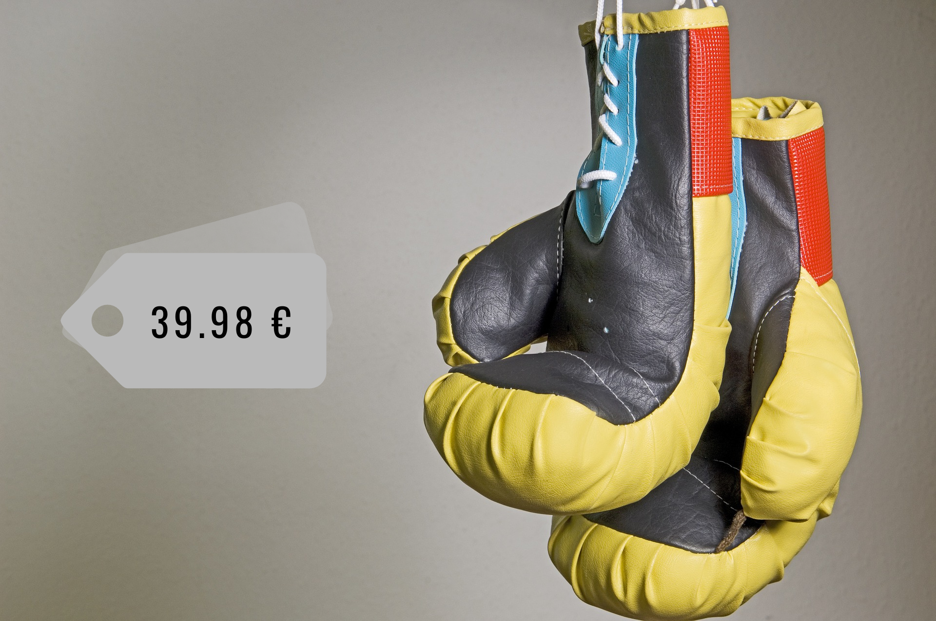 Na zdjęciu znajduje się para kolorowych, skórzanych rękawic bokserskich i metka z ceną 39,98 euro.