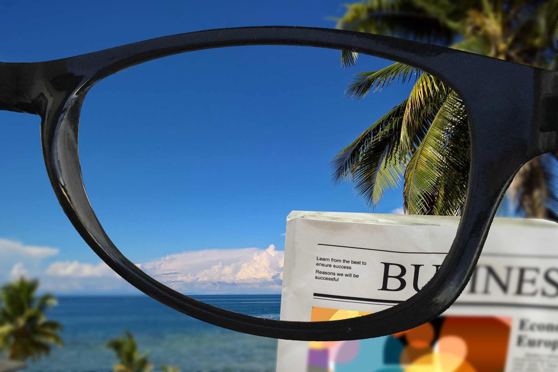 Rys. 3. Zdjęcie przedstawia w powiększeniu jedno szkło okularów progresywnych. Za okularami na pierwszym planie pokazano fragment gazety, a dalej widoczny krajobraz z palmą, morzem i niebem z białymi chmurami. Fragmenty gazety i dalekiego krajobrazu widziane przez szkło okularów są ostre, a wszystkie elementy obrazu poza korekcją szkła są nieostre, rozmyte.