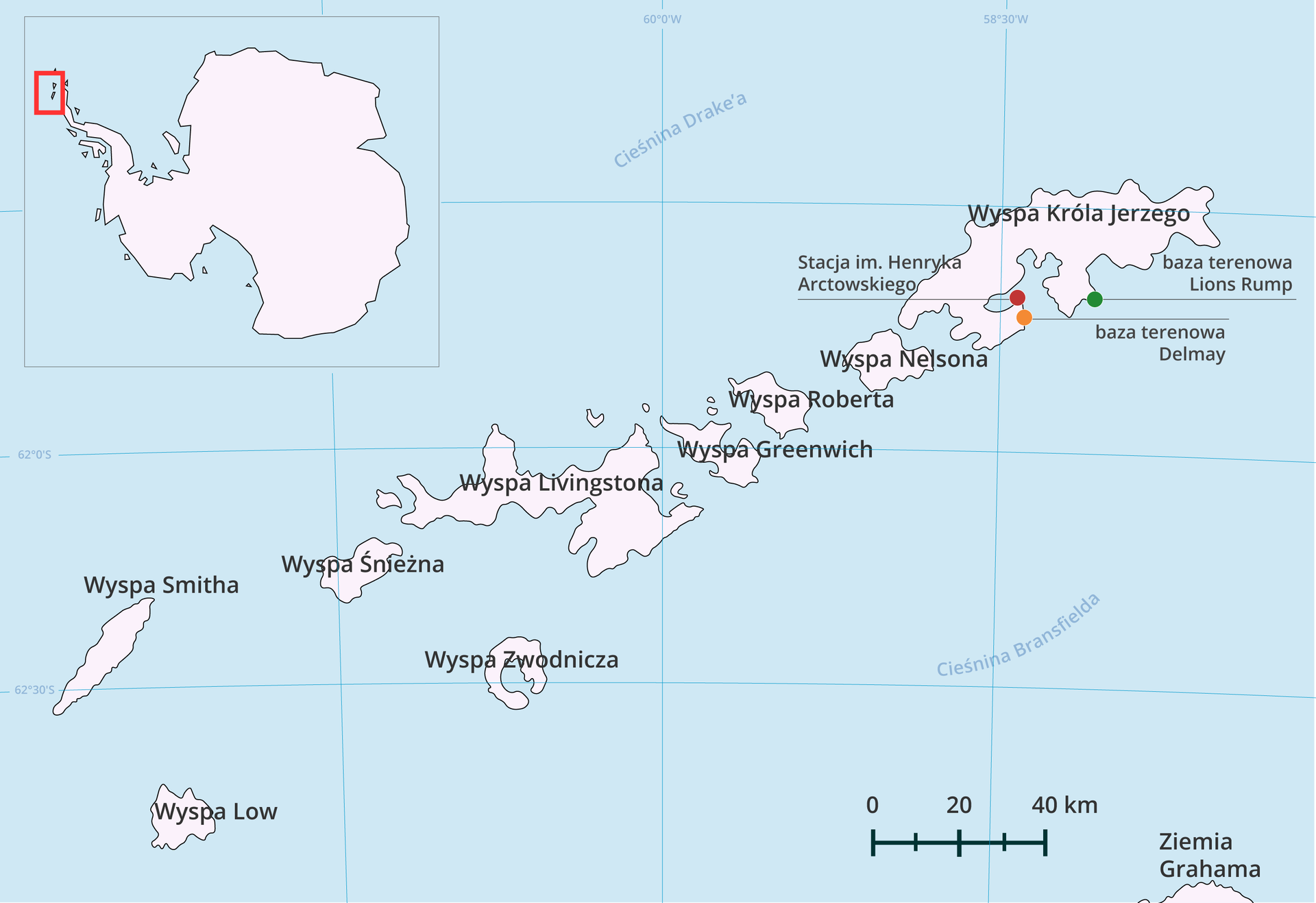 Grafika przedstawia archipelag Szetlandów Południowych. W lewym górnym rogu mapa całej Antarktydy wraz z oznaczonym na niej archipelagiem. Na północ od niego znajduje się Cieśnina Drake’a, na południe Cieśnina Bransfielda. Kropkami oznaczono trzy stacje położone na Wyspie Króla Jerzego w jej południowej części, największej z całego archipelagu, położonej na północnym wschodzie. Jest to stacja imienia Henryka Arctowskiego, baza terenowa Delmay, baza terenowa Lions Rump.