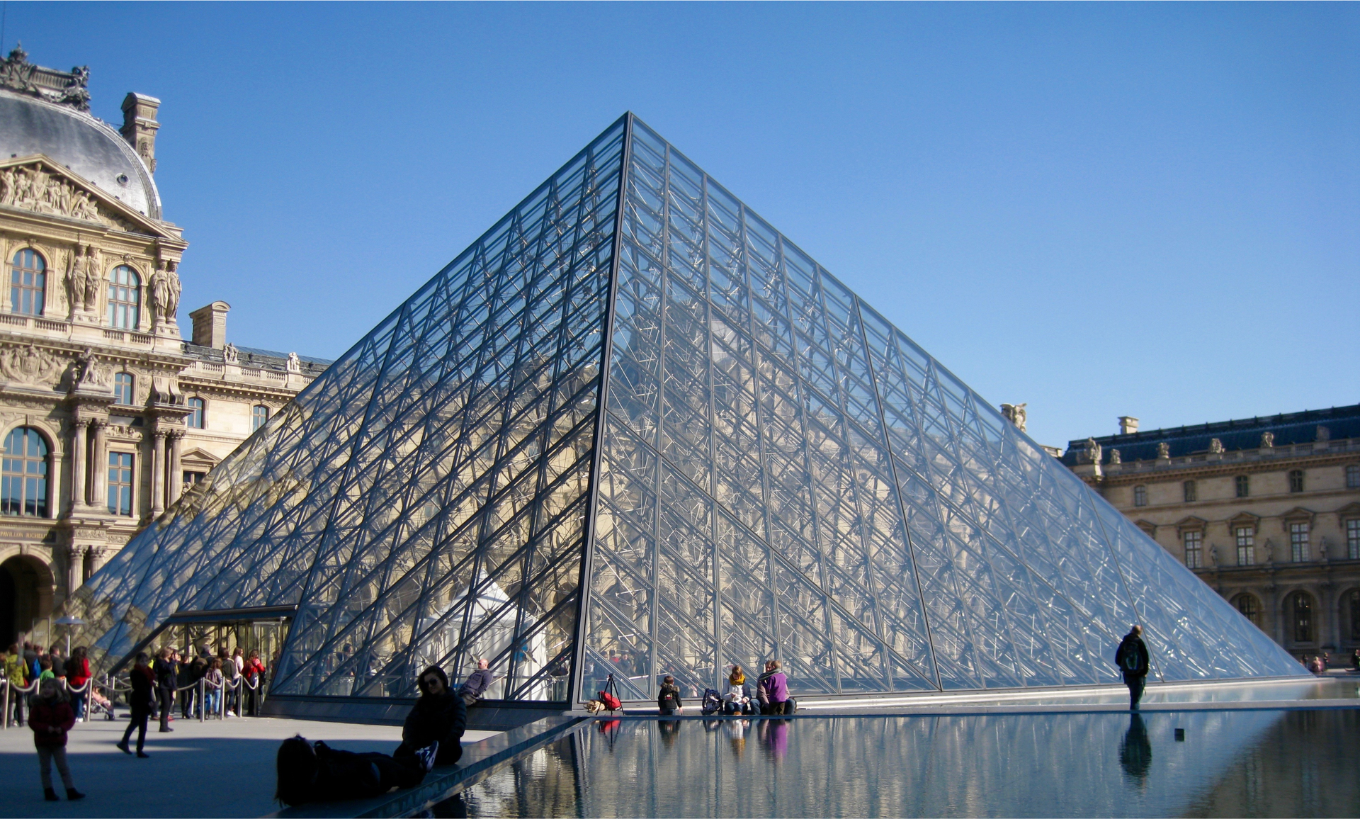 Zdjęcie przedstawia szklaną piramidę  w Luwrze. 