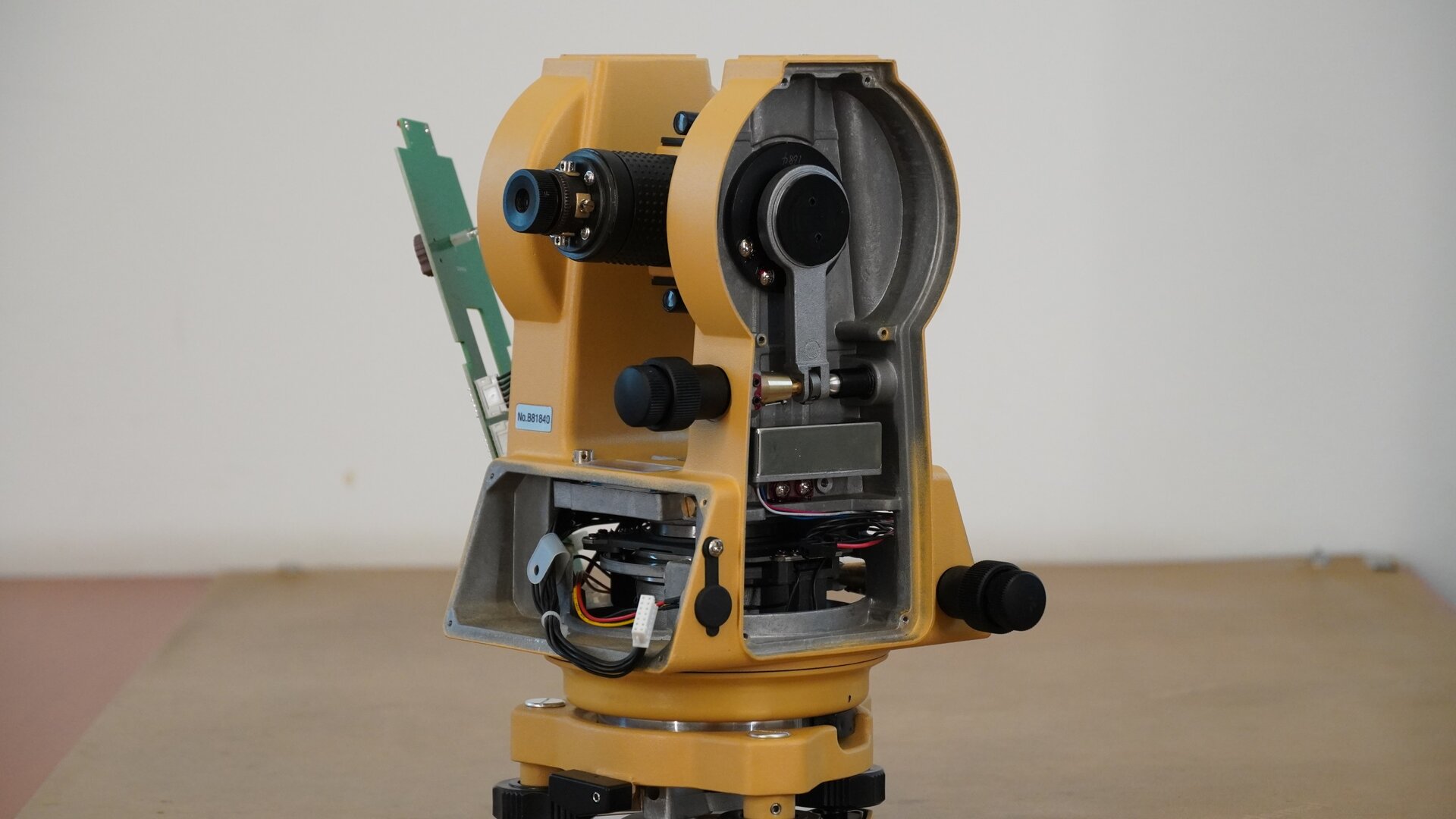 Na zdjęciu ukazano boczne ujęcie tego instrumentu pomiarowego. Po lewej stronie znajduje się okular, pod nim miejsce z przewodami po zdemontowanym wyświetlaczu. Boczna osłona urządzenia również została zdemontowana. Dzięki temu widoczny jest mechanizm śruby leniwej.