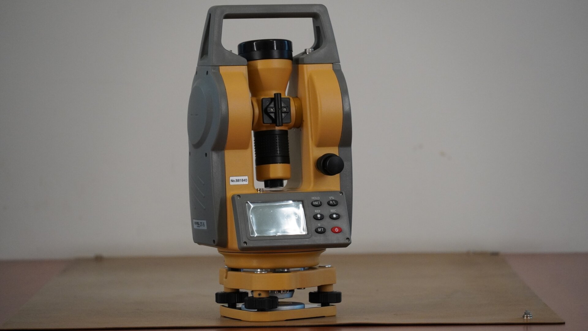 Zdjęcie przedstawia teodolit ze złożoną lunetą. W tej pozycji okular lunety znajduje się na dole, a obiektyw na górze.