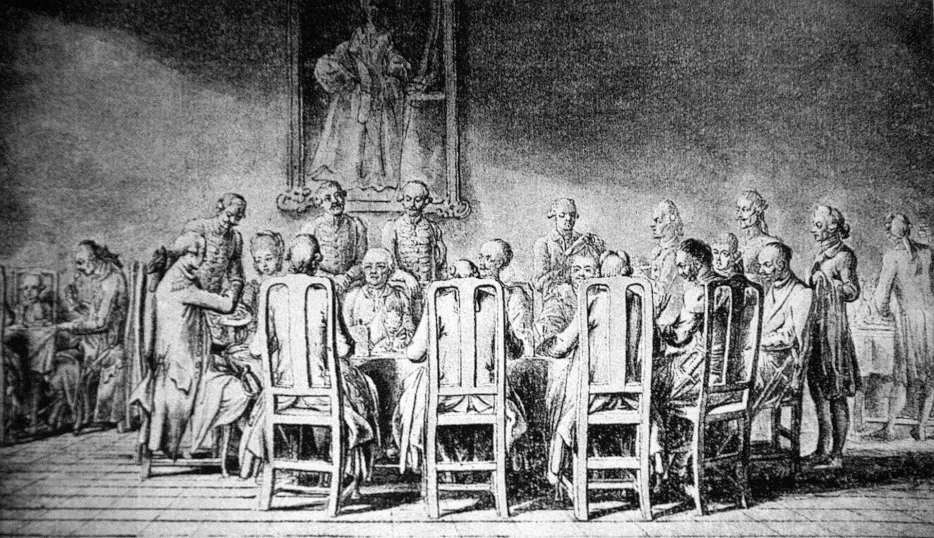 Rycina przedstawia mężczyzn i jedną kobietę, którzy siedzą wokół stołu na krzesłach z wysokimi oparciami. Część z nich siedzi tyłem do oglądającego tak, że widoczne są tylko oparcia i tył ich głów; dwóch mężczyzn siedzi bokiem przy krótszych krawędziach stołu, pozostali siedzą przodem do widza. Za biesiadnikami stoi służba w liberiach. Na ścianie wisi niewyraźny portret kobiety. Rysunek jest czarno‑biały.